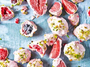 Berries coated in frozen yoghurt and sprinkled with nuts