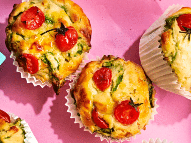 An aerial view of the top of tomato and cheese savoury muffins with spinach.